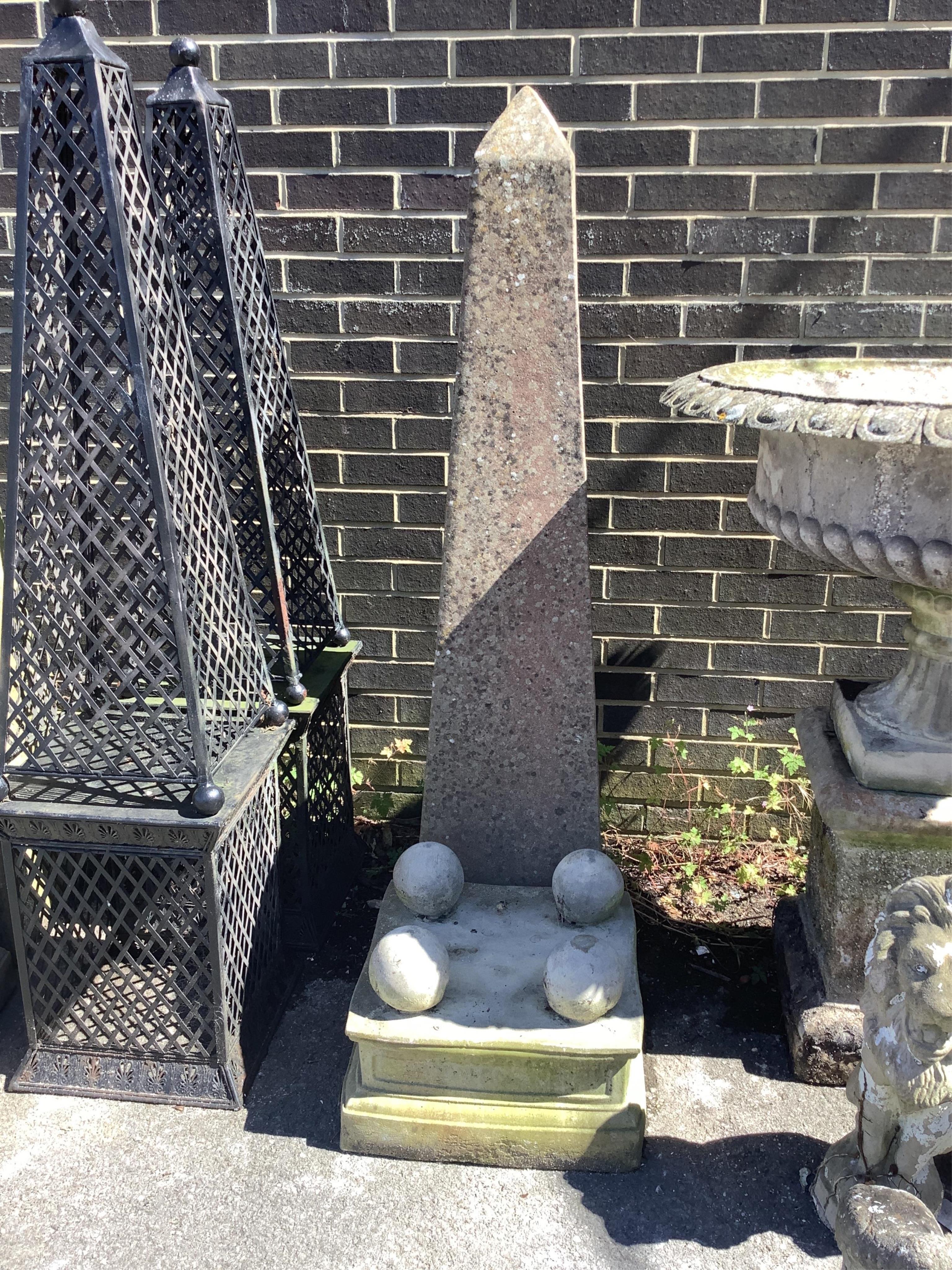 A pair of reconstituted stone obelisk garden ornaments on stands, height 180cm. Condition - fair